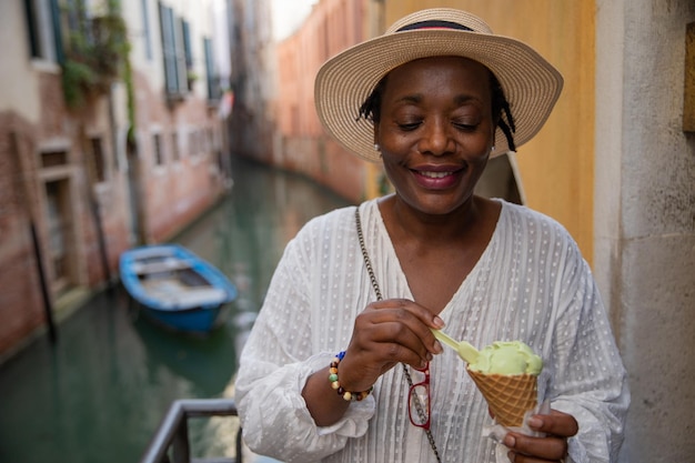 Una signora mangia il gelato mentre è in vacanza a Venezia Italia Donna turistica matura durante il suo viaggio