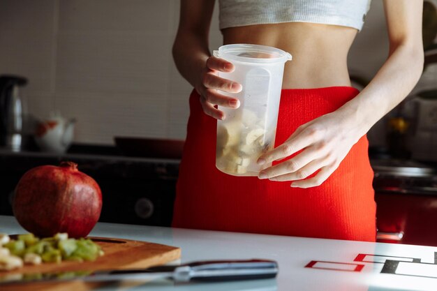 Una signora sta cucinando un frullato di banana in cucina Vista ravvicinata delle mani