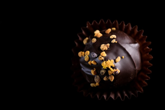 Una singola pralina di cioccolato fatta a mano Vista ravvicinata su sfondo scuro con spazio di copia
