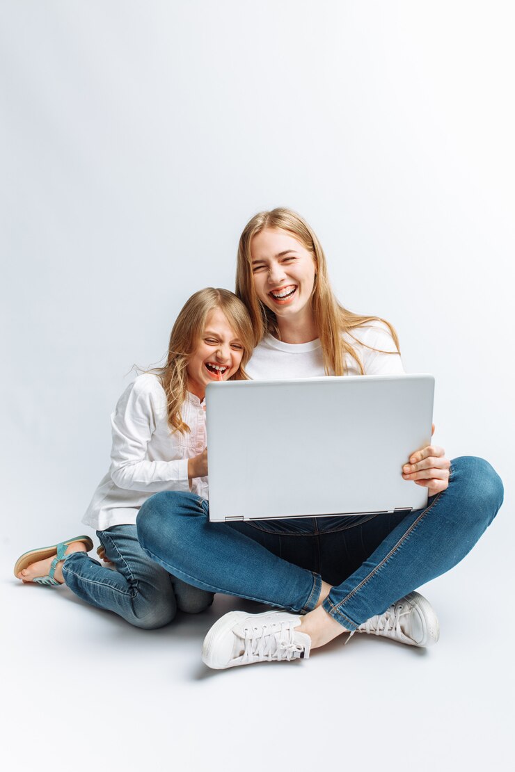 Una sorella o una giovane madre con sua figlia che guardano un film sul mio laptop, si divertono, ridono