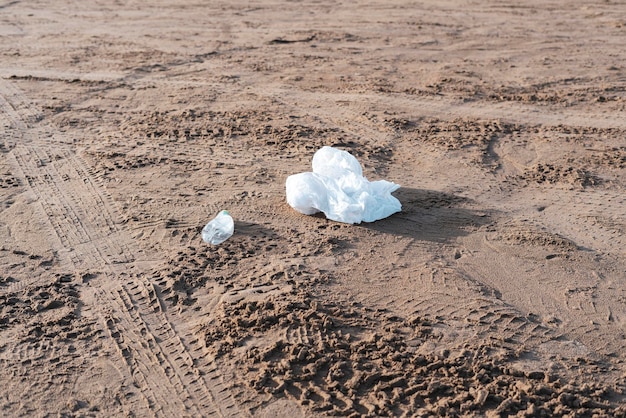 Una spazzatura di plastica gettata sulla costa sabbiosa della spiaggia, problema ecologico