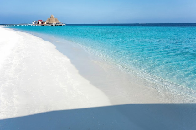 Una spiaggia con acqua blu e una spiaggia di sabbia bianca.