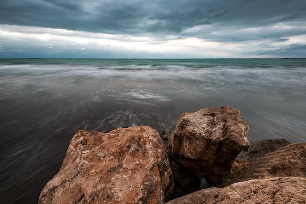 Una spiaggia con rocce e un cielo nuvoloso