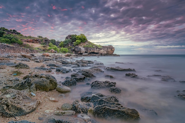 Una spiaggia con scogli e il cielo al tramonto