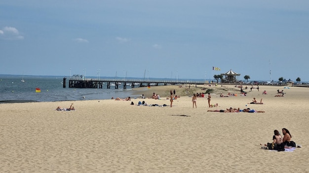 Una spiaggia con un molo sullo sfondo