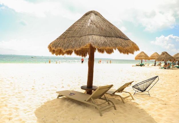 Una spiaggia con un ombrellone di paglia e sedie