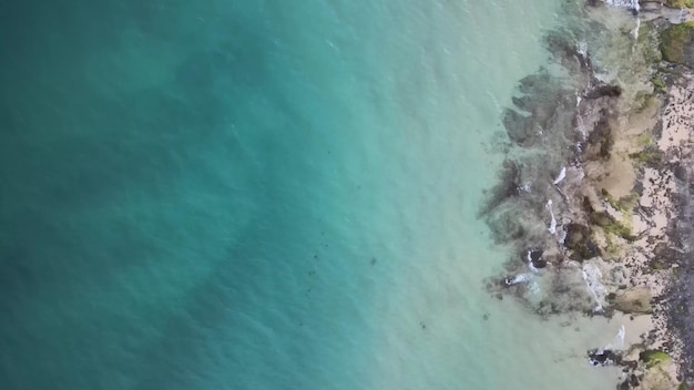 Una spiaggia con una piccola isola in mezzo all'oceano.