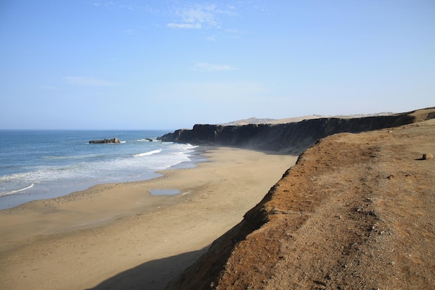 Una spiaggia con una scogliera sullo sfondo