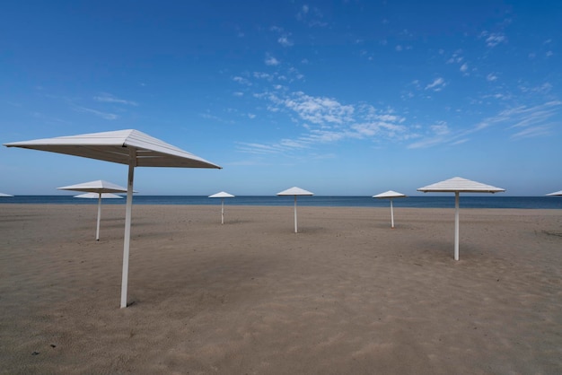 Una spiaggia deserta con ombrelloni in legno sulla riva del Mar Baltico nel villaggio di Yantarny regione di Kaliningrad Russia