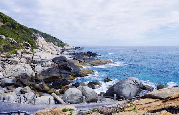 Una spiaggia rocciosa con un oceano blu e un cielo nuvoloso