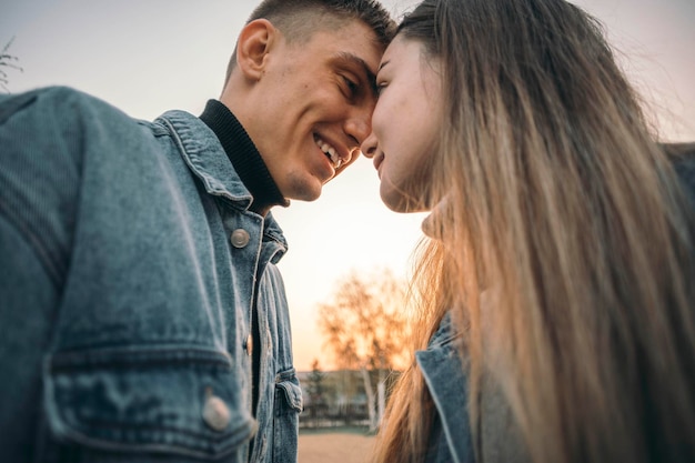 Una splendida, sensuale giovane coppia innamorata che posa al tramonto, un concetto di stile di vita felice.