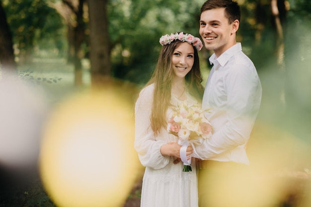 Una sposa e lo sposo posano per una foto in una foresta.