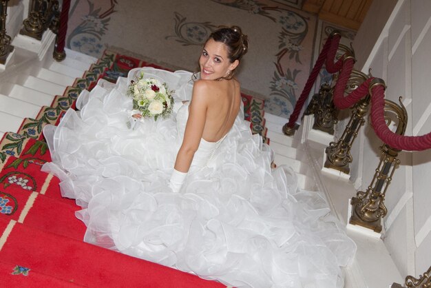 Una sposa è seduta sulle scale