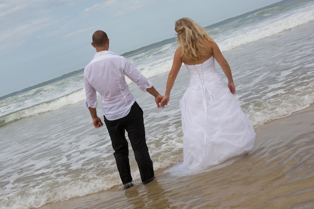 Una sposa e uno sposo attraenti che si sposano sulla spiaggia