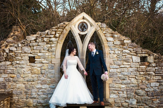 Una sposa e uno sposo mano nella mano il giorno del loro matrimonio in un giardino