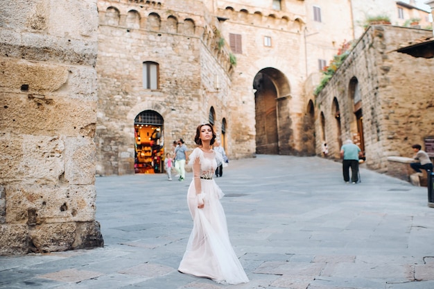 Una sposa in abito bianco nel centro storico di San Gimignano.