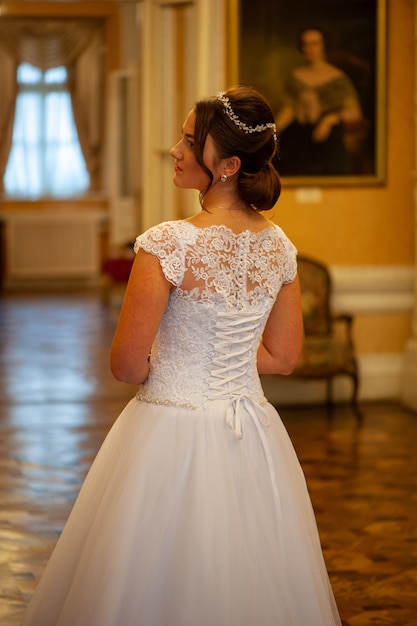 Una sposa in abito bianco si trova nella sala da ballo delle sale di rappresentanza in st. pietroburgo