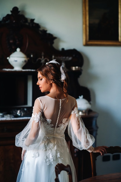 Una sposa in biancheria intima e una veste bianca all'interno di una villa in Italia a un matrimonio.mattina della sposa in Toscana.boudoir sessione fotografica presso la Villa.