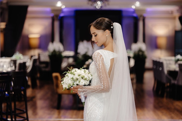 una sposa in un vestito bianco che tiene un bouquet di fiori