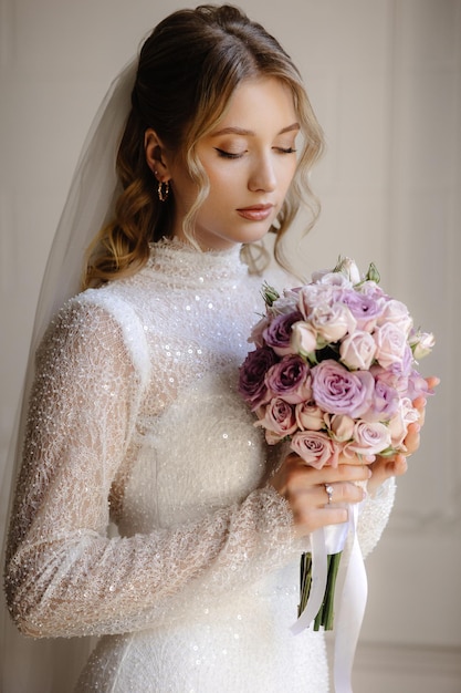 una sposa in un vestito bianco che tiene un bouquet di fiori