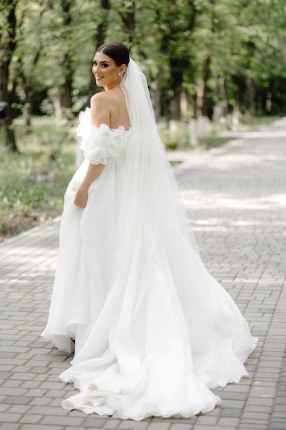 una sposa in un vestito bianco con un lungo velo sulla testa