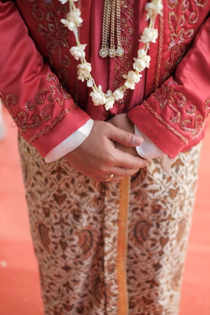Una sposa indossa un abito tradizionale con un disegno floreale sul davanti.