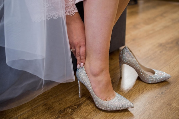 Una sposa si mette le scarpe da sposa