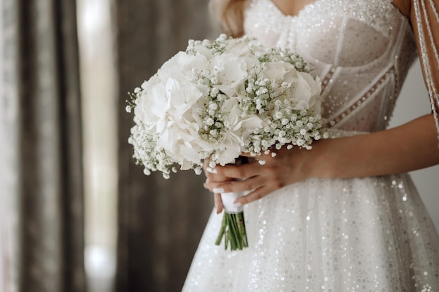 Una sposa tiene in mano un mazzo di fiori.