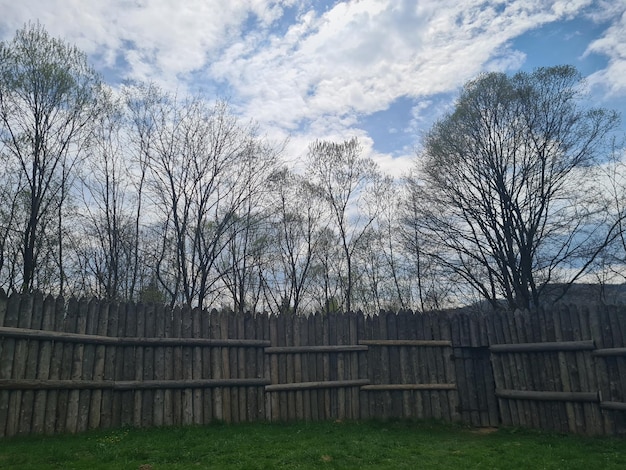 Una staccionata in legno con alberi sullo sfondo