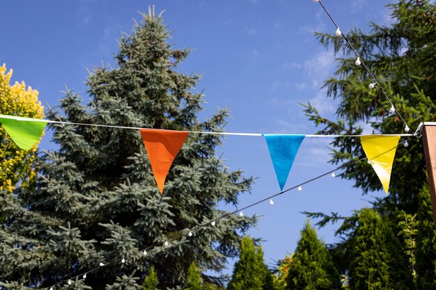 Una stamina triangolare blu e arancione è appesa nel giardino.