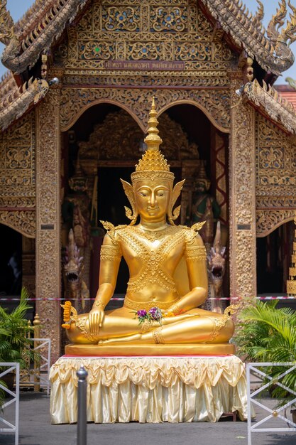 Una statua d'oro di un buddha siede in un tempio.