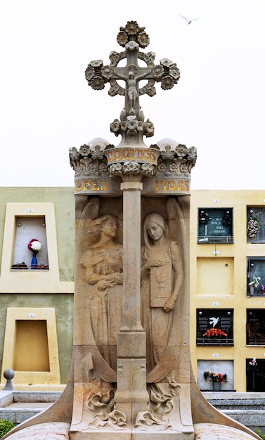 Una statua di due donne con sopra una croce
