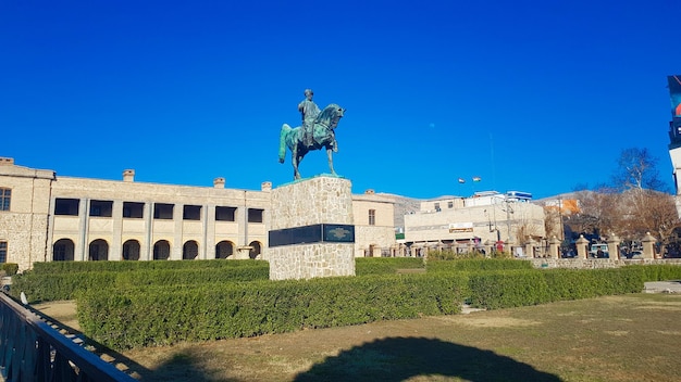 Una statua di un uomo a cavallo si trova di fronte a un edificio.