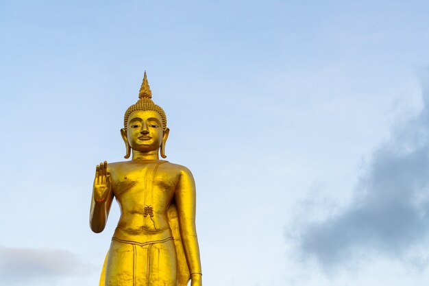 Una statua dorata del Buddha con il cielo sulla cima della montagna al parco pubblico del comune di Hat Yai, provincia di Songkhla, Thailandia
