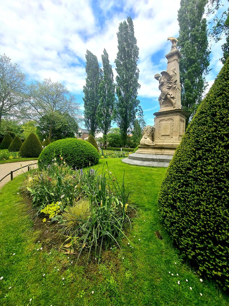Foto una statua in un parco con una statua in primo piano