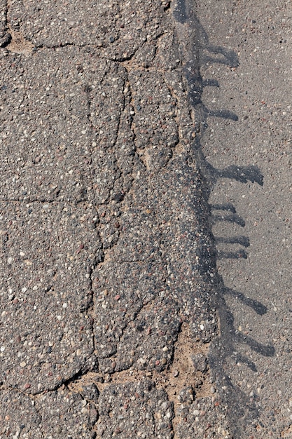 Una strada asfaltata con molte buche e buche