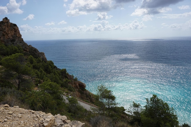 Una strada che porta al mare con il sole che splende su di essa.