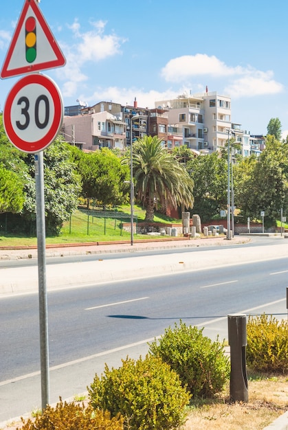 Una strada con sospiri di traffico in primo piano e case e alberi sullo sfondo a Istanbul