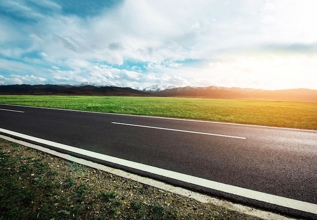 Una strada con un campo sullo sfondo