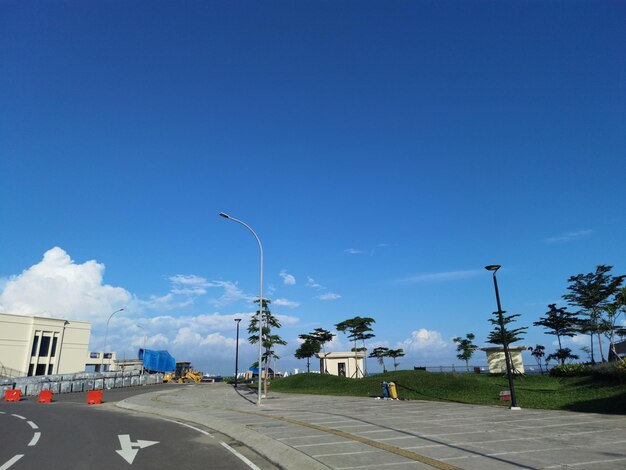 una strada con una strada e un edificio sullo sfondo con cielo blu e nuvola