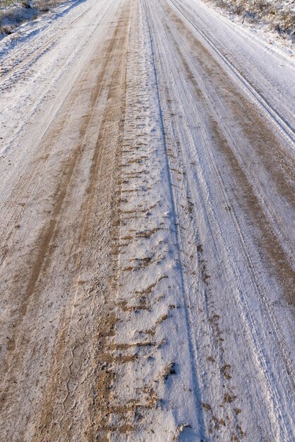 Una strada coperta di neve e ghiaccio per le auto una strada stretta dopo una nevicata è scivolosa e pericolosa perché coperta di neve e ghiaccio