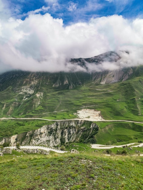 Una strada tra le montagne del Daghestan con grandi montagne sullo sfondo e nuvole Russia