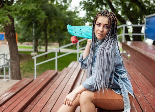 Una straordinaria pattinatrice con skateboard afrobraids siede sul podio