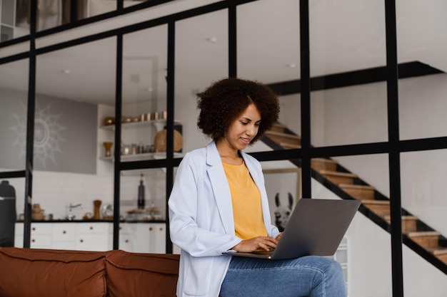 Una studentessa africana intelligente con un computer portatile studia l'inglese online alla scuola linguistica a casa Attraente donna afroamericana ha una lezione di comunicazione video con l'insegnante