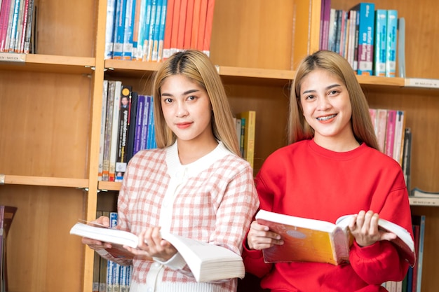 Una studentessa che legge un libro nella biblioteca dell'università