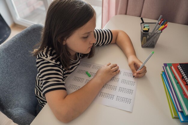 Una studentessa fa i compiti a casa. Il concetto di ritorno a scuola.