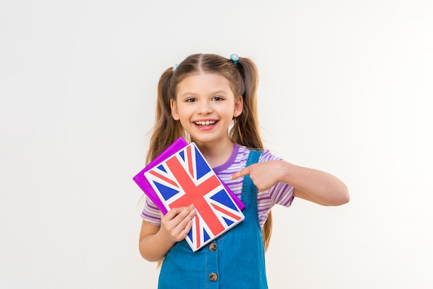 Una studentessa punta il dito contro un libro di testo inglese. Studio e traduzione di lingue straniere.