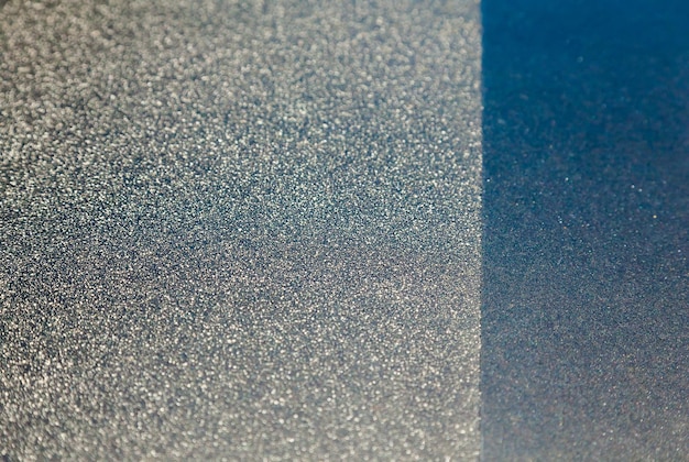 Una superficie ruvida argentea e blu scuro separata da una linea retta