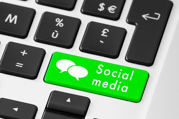 Una tastiera per laptop con un pulsante verde che dice social media.