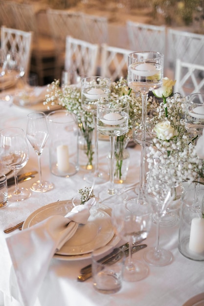 Una tavola apparecchiata per un matrimonio con un portacandele e un bicchiere d'acqua.